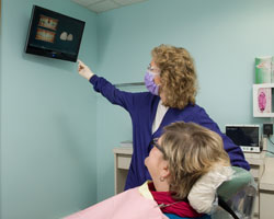 Hygienist using a procedure video to explain treatment to the patient